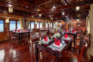 un restaurante con mesas y sillas con sombreros de Santa en Cozy Bay Classic Cruise, en Ha Long