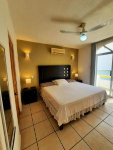 Hacienda Real Suits Ixtapa في اكستابا: غرفة نوم بسرير كبير ونافذة