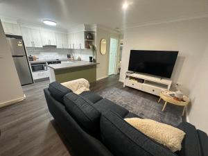 a living room with a couch and a tv at Central Evans Wagga Apartments in Wagga Wagga