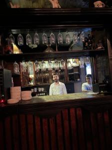 two men standing behind a bar in a restaurant at Italian House in Baghdād