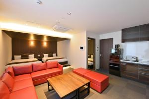 a hotel room with a couch and a bed at GRAND BASE Hiroshima Peace Memorial Park in Hiroshima