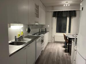 a white kitchen with a sink and a stove at Apartment Korsholma1 in Vaasa