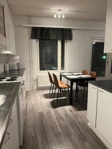 a kitchen with a table and chairs and a dining room at Apartment Korsholma1 in Vaasa