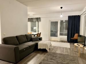 un soggiorno con divano e tavolo di Apartment Korsholma1 a Vaasa
