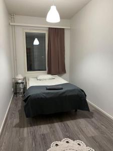a small bedroom with a bed and a window at Apartment Korsholma1 in Vaasa