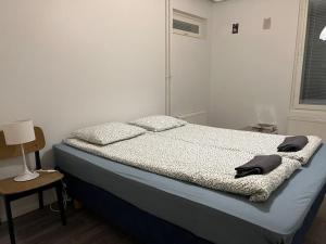 - une chambre avec un lit et une table avec une lampe dans l'établissement Apartment Korsholma1, à Vaasa