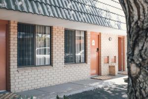 a brick building with an orange door and windows at The Timothée Resort in Busselton