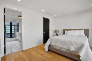 a white bedroom with a bed and a large window at Central DC Home+Private Rooftop! (Unit B) in Washington, D.C.