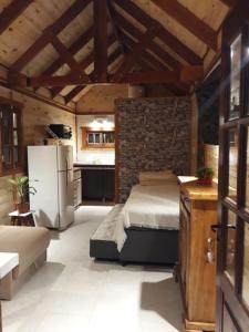 a kitchen and a bedroom with a bed and a refrigerator at CASITA DE MARIA in Paso de la Patria