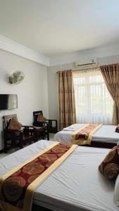 a hotel room with two beds and a window at Thanh Ha Hotel in Chơ Mơi