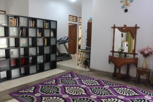 uma sala de estar com um tapete roxo e uma estante de livros em Homestay Bougenville Antapani Syariah em Bandung