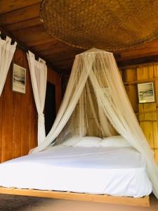 - un lit avec moustiquaire dans l'établissement Motho Homestay โมโทโฮมสเตย์, à Chom Thong