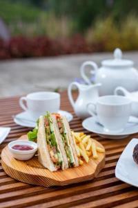 a sandwich and french fries on a wooden table at The paulwood home cabin in Nuwara Eliya
