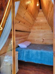 łóżko na środku drewnianego poddasza w obiekcie Campestre Camp w mieście Chignahuapan
