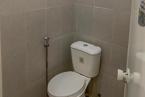 a small bathroom with a toilet in a room at RedDoorz Syariah near Universitas Muhammadiyah Jember in Jember