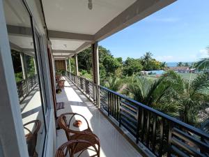 Un balcón con sillas y vistas al océano. en Roomy Guesthouse en Koh Rong Island