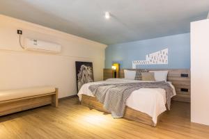 1 dormitorio con cama y banco. en Lavender Apartment Branch, en Guangzhou