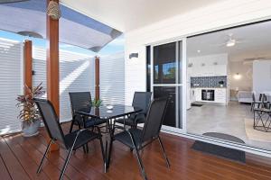 a dining room with a table and black chairs at Modern Luxury Studio Apartment in Emu Park