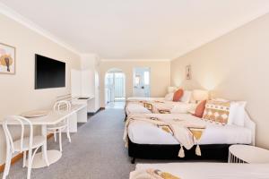 a hotel room with two beds and a table at Harbourview House in Bermagui