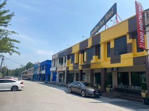 a street with cars parked in front of a building at OYO 90883 Pavilion Inn Hotel in Lumut