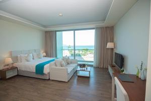 a large hotel room with a bed and a couch at Alacarte Luxury Ocean View Condotel in Da Nang