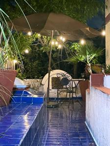 een patio met een parasol en een tafel bij Coyoacan, 2 level Cozy apartment 3Bedrooms, 3Bathrooms, Terrace in Mexico-Stad