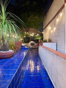 a swimming pool with blue tiles on a patio at night at Coyoacan, 2 level Cozy apartment 3Bedrooms, 3Bathrooms, Terrace in Mexico City
