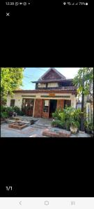 a large building with a large door in front of it at Watthat & Maladreds GUESTHOUSE dorm 1 in Luang Prabang