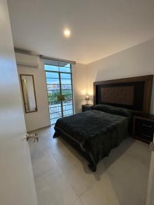 a bedroom with a bed and a large window at En el centro de Guadalajara con vista a la ciudad in Guadalajara