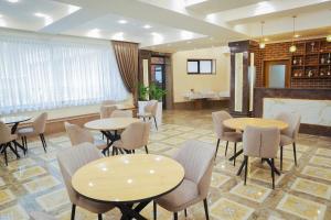a restaurant with tables and chairs and a fireplace at Riviera in Bishkek