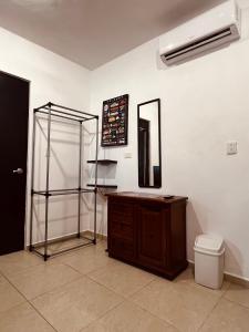 een badkamer met een toilet, een wastafel en een spiegel bij Habitación independiente al Norte de Mérida in Mérida