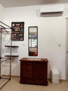 uma casa de banho com um toucador e um espelho na parede em Habitación independiente al Norte de Mérida em Mérida