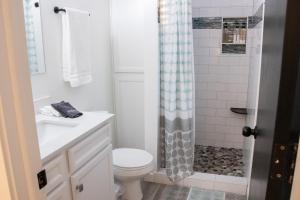 a white bathroom with a toilet and a shower at Hyde Park Haven - your home away from home - minutes north of Logan and USU in Hyde Park +15 photos