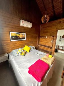 1 dormitorio con 1 cama con 2 mantas en POUSADA ROSA e POESIA en Praia do Rosa