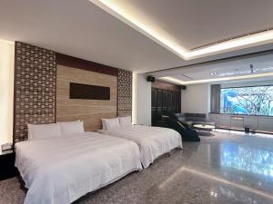 a bedroom with two beds and a living room at Orient Luxury Villa Motel in Huwei