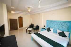 a bedroom with a blue and white bed and a table at Raj Residency in Jodhpur