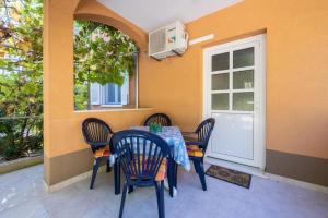a patio with a table and chairs and a window at Apartment Perka - peaceful in Vrboska