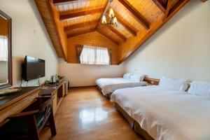 a bedroom with two beds and a tv and a ceiling at Tai-Yi Red Maple Resort in Puli