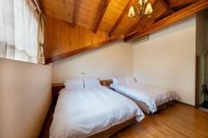 埔里鎮的住宿－楓樺台一渡假村(台一生態休閒農場)，配有木天花板的客房设有两张床。