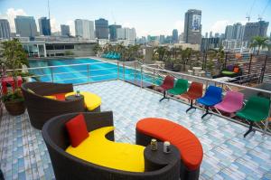 een balkon met kleurrijke stoelen en een zwembad in een gebouw bij Witchuwan Apartel in Bangkok