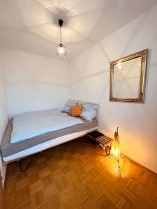 una camera da letto con un letto con specchio e lampada di Ferienwohnung zum Wohlfühlen a Gmunden