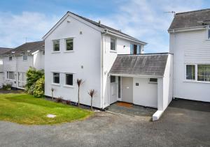 a white house with a garage at 4 Ynys Fawr in Abersoch