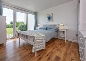 a bedroom with a bed and a large window at 4 Ynys Fawr in Abersoch