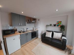 een woonkamer met een bank en een keuken bij The Cozy Landport Loft in Portsmouth