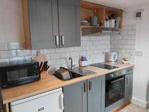 a kitchen with a sink and a microwave at The Cozy Landport Loft in Portsmouth