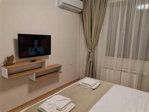 a bedroom with a bed and a tv on a wall at Family Boutique Residence-Free parking in Veliko Tŭrnovo