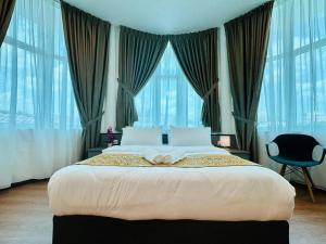 LESTARI INN RESIDENCE في كُوانتان: غرفة نوم بسرير كبير مع نوافذ كبيرة