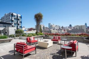 eine Terrasse mit roten Stühlen und Tischen und einer Stadt in der Unterkunft Lower Nob Hill 1BR w Gym Roof nr bars SFO-689 in San Francisco