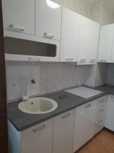 a kitchen with a sink and white cabinets at Apartment Tijana in Sutomore