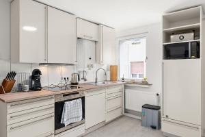 a kitchen with white cabinets and a sink at EasyGoing Switch Streaming schönes Apartment 6 Personen in Arnsberg